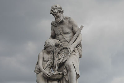 Low angle view of statue against cloudy sky at dusk