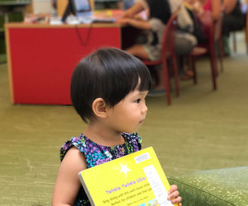 Cute girl looking away holding a book