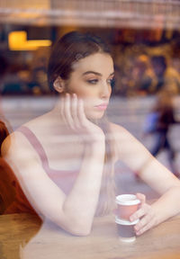 Portrait of young woman at cafed looking out the window
