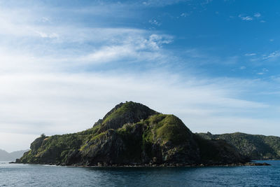 Scenic view of sea and mountains against sky