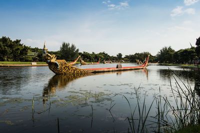 Boats moored on lake against sky