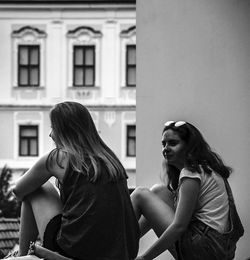 Side view of a young woman sitting outdoors