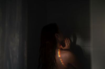 Side view of woman looking at dark room