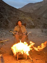 Portrait of man sitting on fire