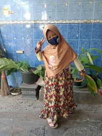 Portrait of woman standing against wall