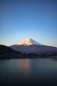 Scenic view of snowcapped mountains against clear blue sky