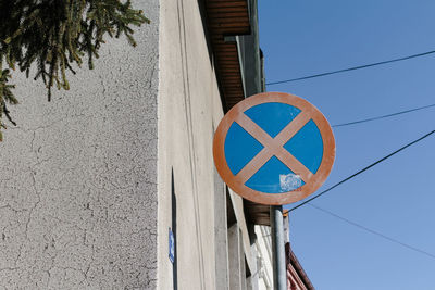 Low angle view of road sign against clear blue sky