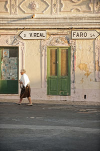 Full length of woman walking in front of building