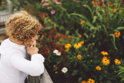 Side view of young woman standing on footbridge at park