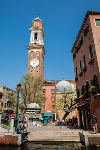 Tourists and locals walking around the beautiful streets of venice in a sunny early spring day