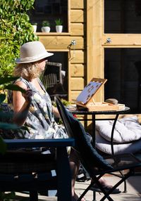 Woman sitting on chair in cafe painting 