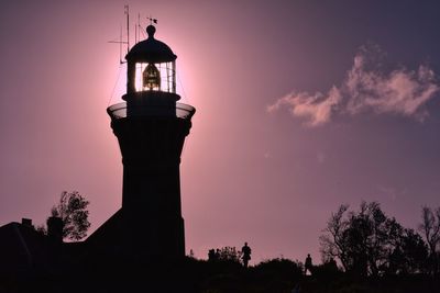 Low angle view of silhouette lighthouse against sky at sunset