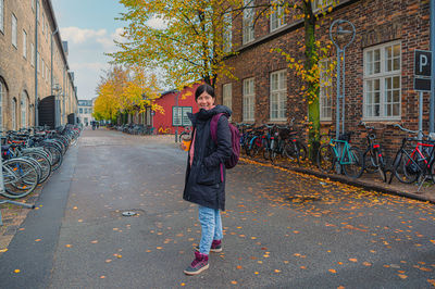 Girl stands on street in the old town among small  houses at dokøen island.copenhagen, denmark