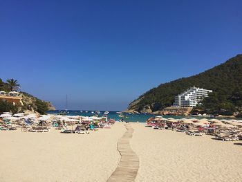 Panoramic view of beach against clear blue sky