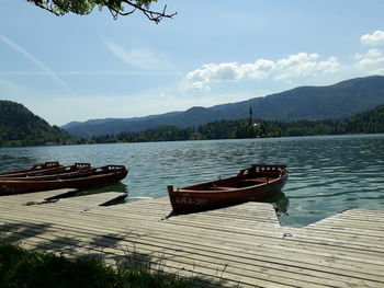 Boats moored on lake against sky