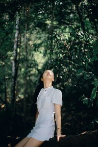 Young woman standing in forest