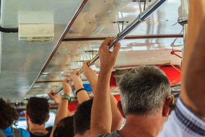 Passengers holding pole in bus