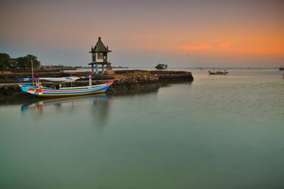 Ship moored in sea against sky during sunset