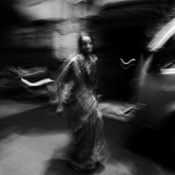 Midsection of woman dancing on street at night