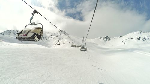 Low angle view of overhead cable car over snowcapped mountain