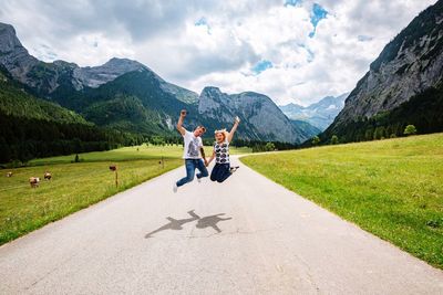 Friends on road amidst mountains against sky