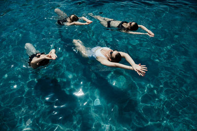 Pool party woman swimming in sync