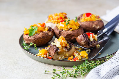 Baked stuffed portobello mushrooms with bulgur pilaf and chopped vegetables. 