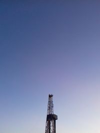 Low angle view of crane against clear sky