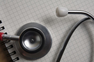Directly above shot of stethoscope on spiral notebook