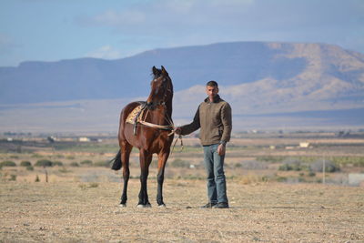 A horse standing on field.