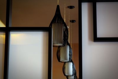 Close-up of electric lamp hanging on wall at home