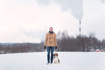 Man with dog standing in snow