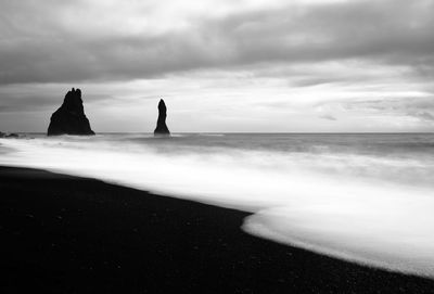 Scenic view of beach and sea against cloudy sky