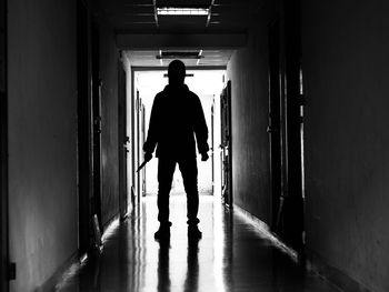 Rear view of silhouette man walking in corridor of building