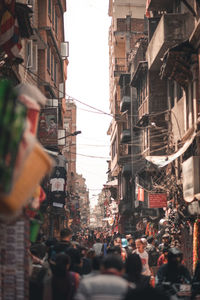 People on street amidst buildings in city