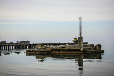 Built structure by river against sky in city