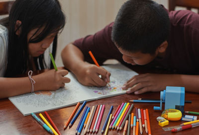 Brother and sister paint the art book together