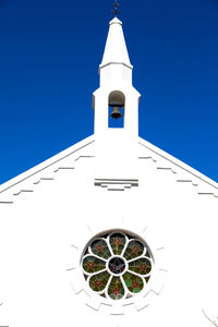 Low angle view of clock tower amidst buildings against clear sky