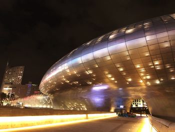 Blurred motion of illuminated city against sky at night