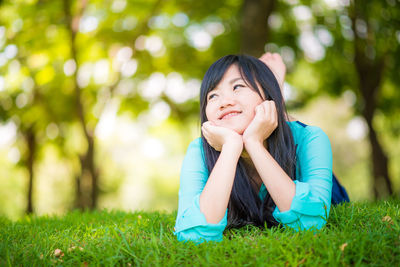 Smiling woman lying on grass at park