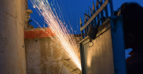 Illuminated light painting on wall against blue sky