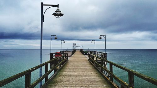 Wooden pier against dramatic sky