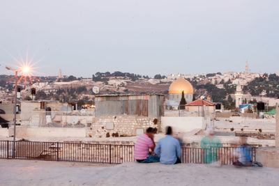 Rear view of people at temple against buildings in city