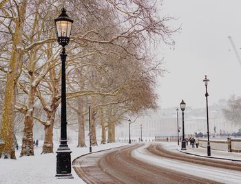 Street light by road against sky during winter