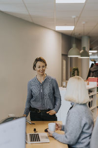 Smiling woman talking in office