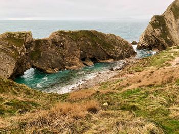 Rock formations by sea against sky