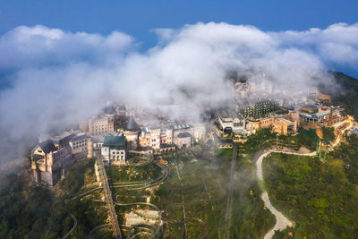 High angle view of buildings and trees against sky