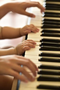 Adult and baby playing the piano together