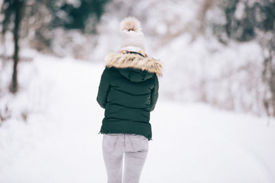 Rear view of man walking on snow
