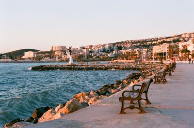 Scenic view of sea by buildings against clear sky